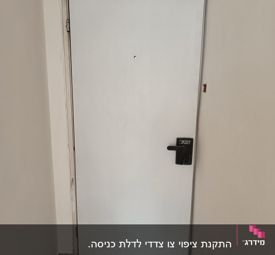 דלת לבנה עם ידית שחורה על רקע קיר לבן